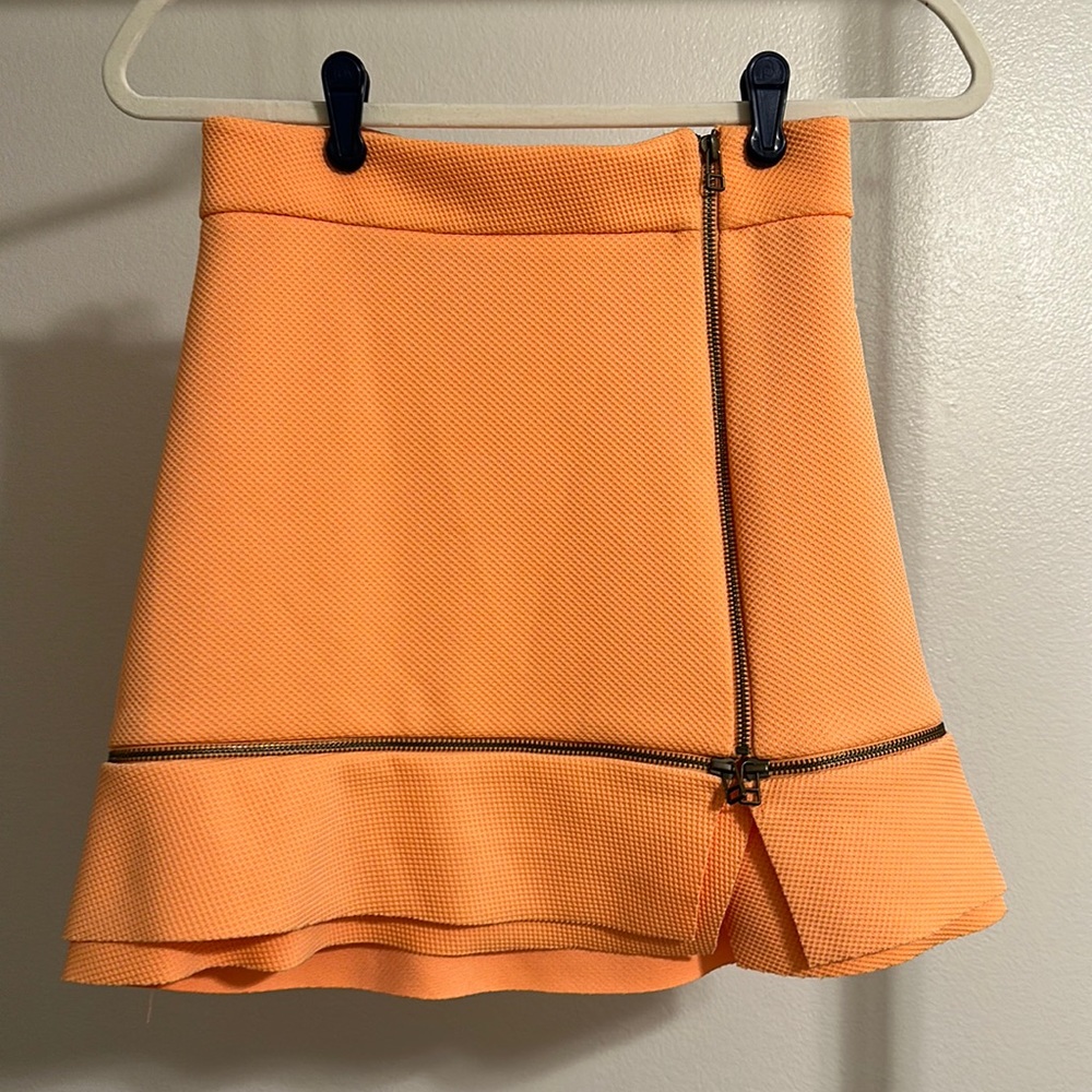 Bright orange mini skirt with bronze zipper detail